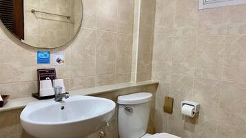 Une salle de bain avec un lavabo, des toilettes et un miroir. Il y a des panneaux sur le mur et un porte-serviettes.