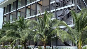 A modern building with multiple balconies, large windows, and a staircase. - Maikaew Damnoen Resort (Damnoen Saduak)