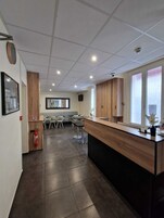 Una cocina moderna con una isla central, un comedor con sillas y un extintor en la pared.