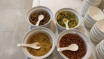 Four bowls of food items on a marble countertop.