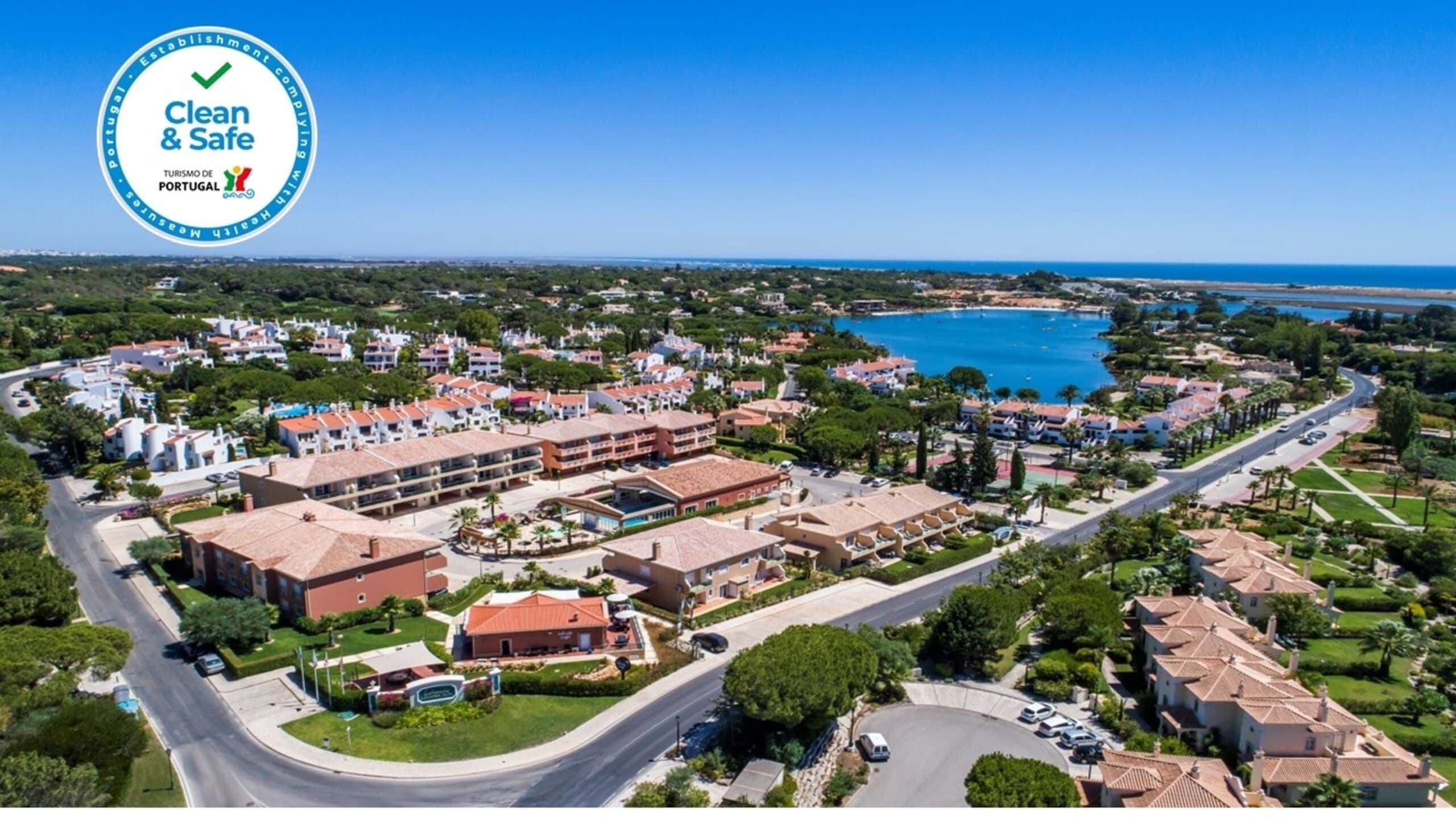 Vista aerea di una località balneare con diversi edifici, strade e una vasta distesa d'acqua.