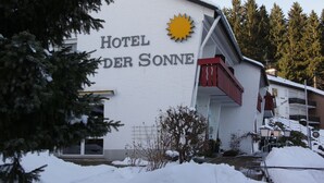 Un edificio con un letrero que dice "HOTEL DER SONNE" y un símbolo de sol.