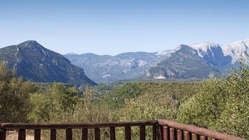 A mountainous landscape with a wooden fence in the foreground.