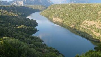 A lake surrounded by forested hills and mountains.