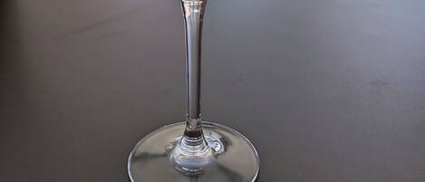 A martini glass with a dark liquid on a table inside a cafe.