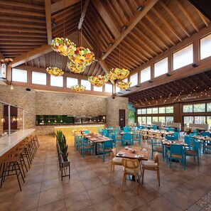 A spacious dining area with high ceilings, exposed wooden beams, and large windows.