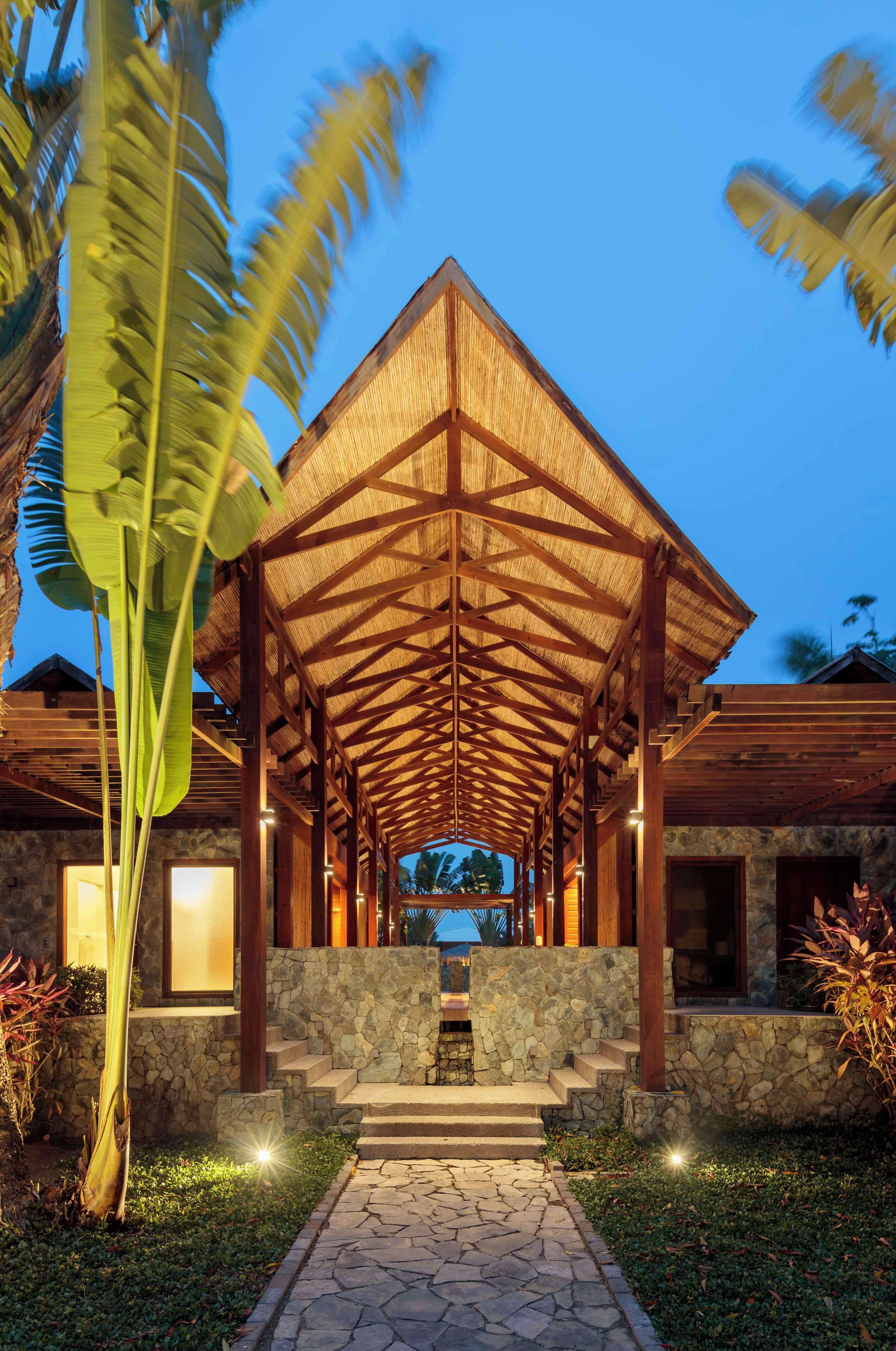 A covered outdoor area with a stone wall and steps leading to a building entrance.