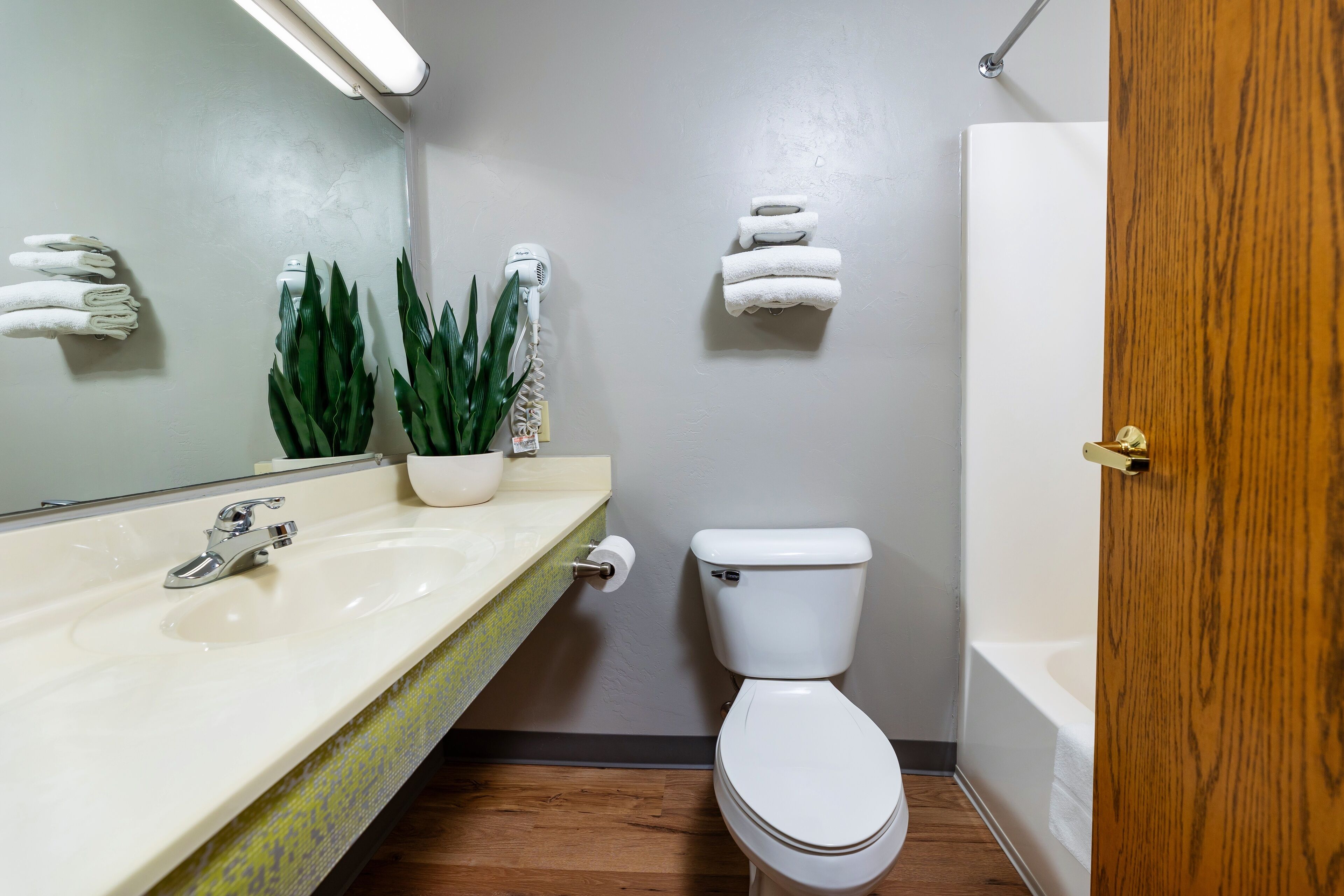Une salle de bain avec un lavabo, des toilettes et une porte en bois.