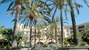 A hotel with multiple floors, palm trees, and a fountain. - Palm Oasis Maspalomas (San Bartolomé de Tirajana)