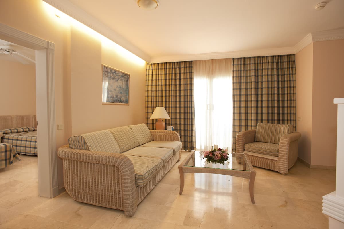 A living room with a sofa, armchair, and coffee table.