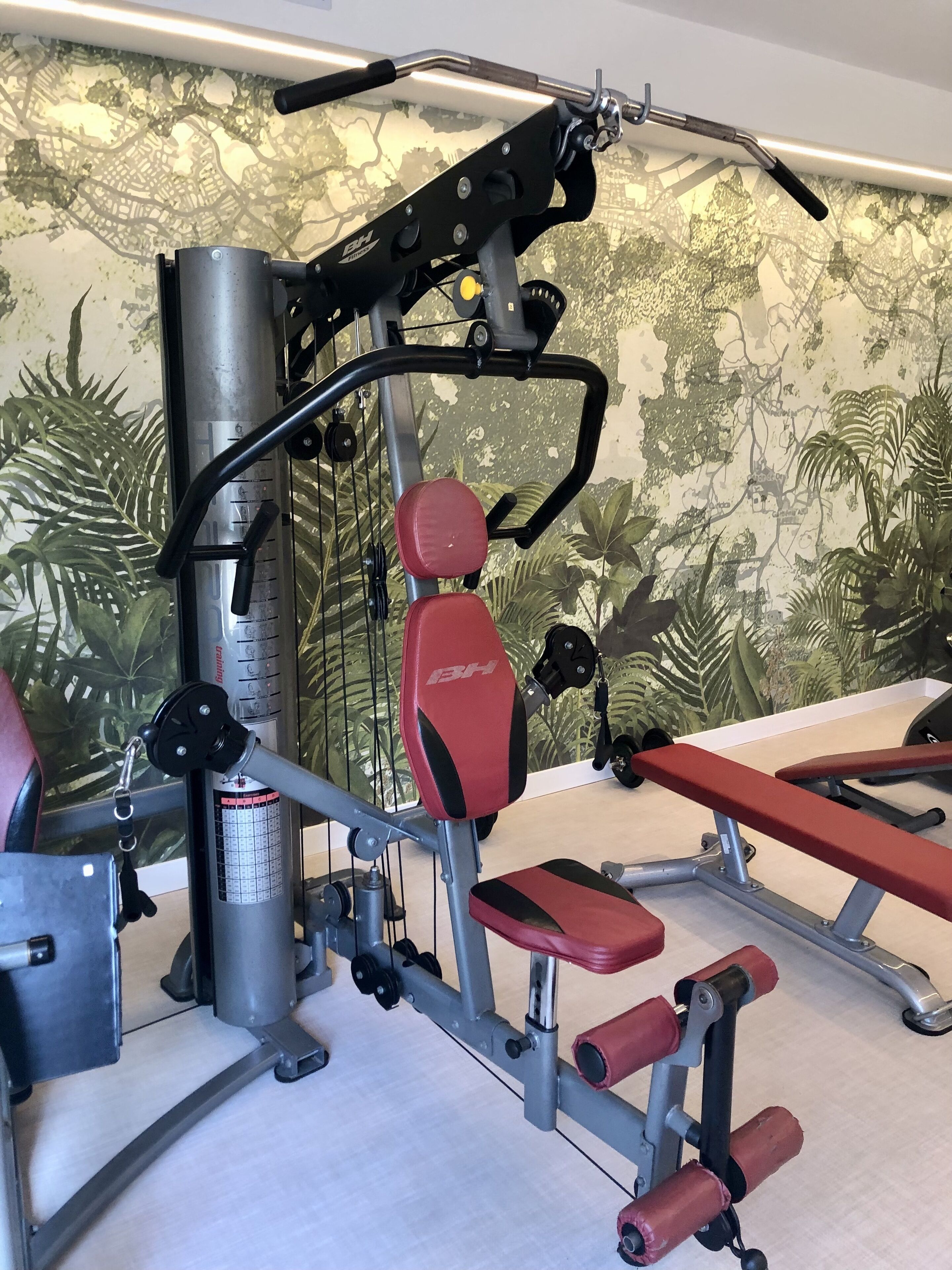 A gym with exercise equipment, including a bench and weight machines.