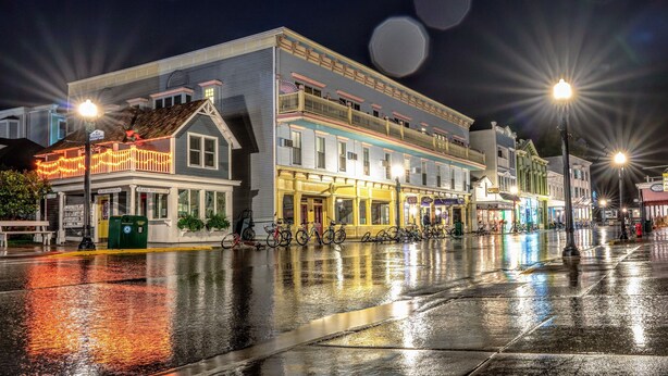 A historic building with a second-floor balcony, a ground-floor restaurant, and a row of bicycles parked outside. - Murray Hotel (Mackinac Island)