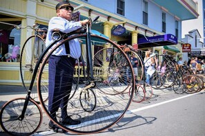 A street scene with vintage bicycles and a person holding a sign. - Murray Hotel (Mackinac Island)