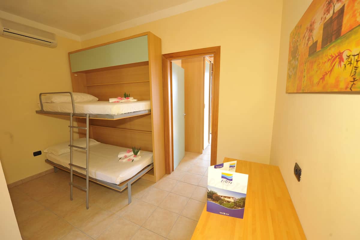 Un dormitorio con literas, un escritorio de madera y un cuadro en la pared.