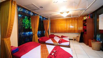 Two single beds with neatly arranged linens and a striped bedspread.