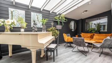 Una sala de estar moderna con un piano, dos sofás y una mesa de centro.