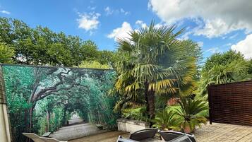 A wooden deck with metal chairs and a mural of a forest.