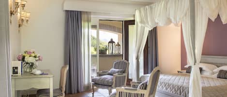 Un dormitorio con cama, dos sillas, un escritorio y una ventana con cortinas.