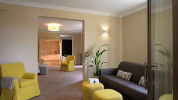 A modern living room with yellow armchairs, a grey sofa, and a large plant.