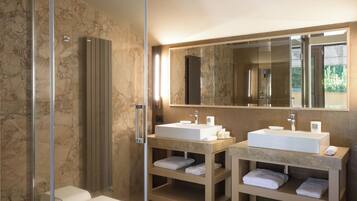 Une salle de bain moderne avec deux lavabos, un grand miroir et une douche à l’italienne.