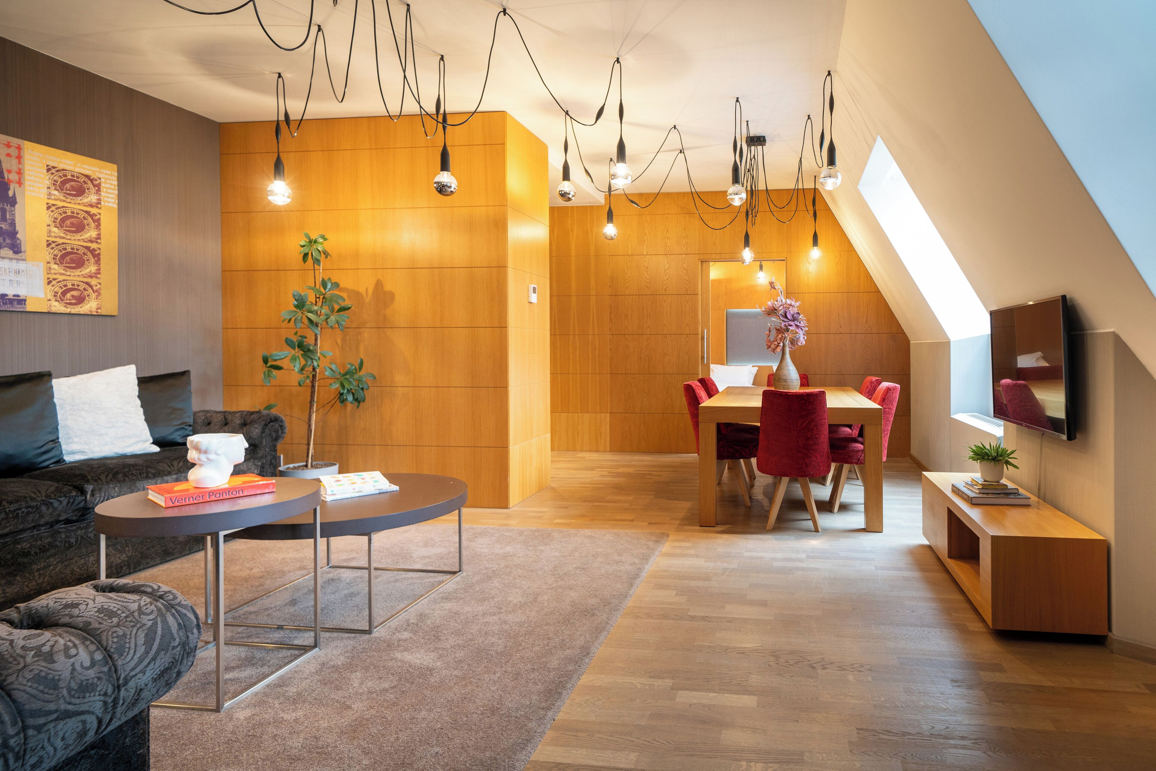 Una sala de estar moderna con sofá, mesa de centro y comedor con mesa y sillas.
