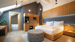 A modern bedroom with a large bed, a grey ottoman, wooden shelving, and a skylight. - INNSiDE by Meliá Prague Old Town (Prague)