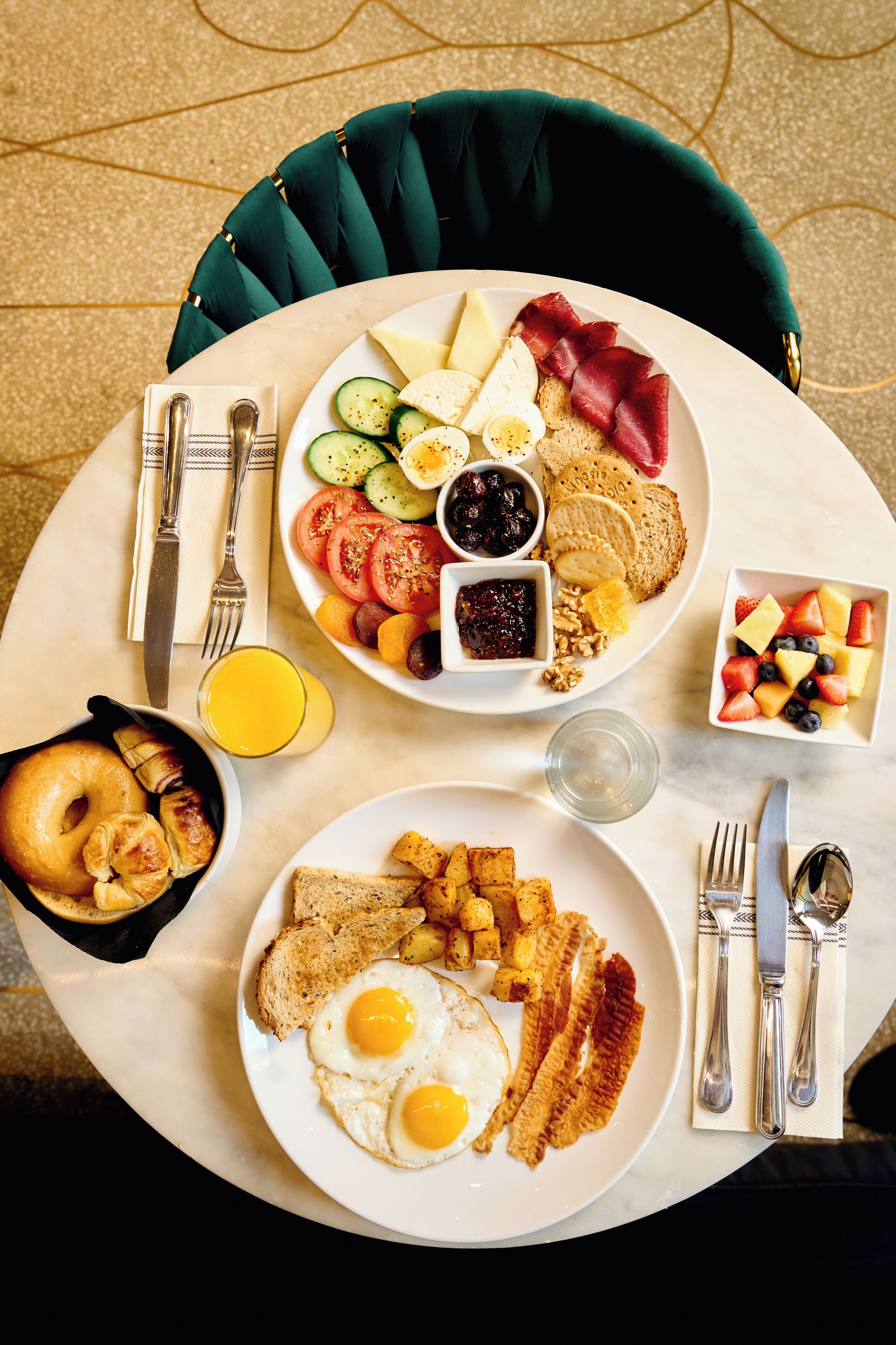 Een ontbijttafel met diverse gerechten, zoals eieren, spek, toast en fruit.