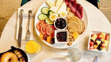 Een ontbijttafel met diverse gerechten, zoals eieren, spek, toast en fruit.