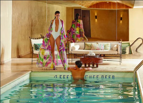 A pool area with a lounge chair and a sofa, a man in a swimsuit, and a woman in a colorful dress. - The Marmara Park Avenue (New York)