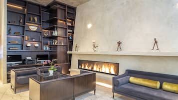 A modern living room with a fireplace, dark wood shelving, and comfortable seating.