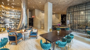 Een modern interieur met een bar, zitplaatsen en een grote tafel.