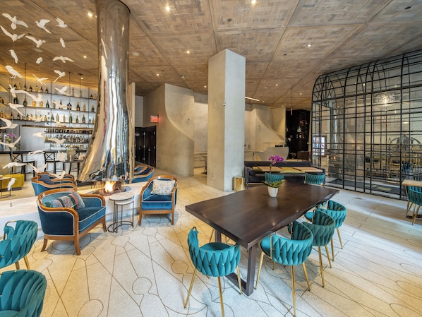 Un interior moderno con una zona de bar, asientos y una mesa grande.
