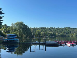 Un lac paisible avec un quai et plusieurs bateaux.