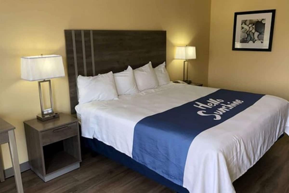 A hotel room with a bed, two bedside tables, and a nightstand.