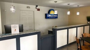 A reception area with a counter, chairs, and a sign for Days Inn.