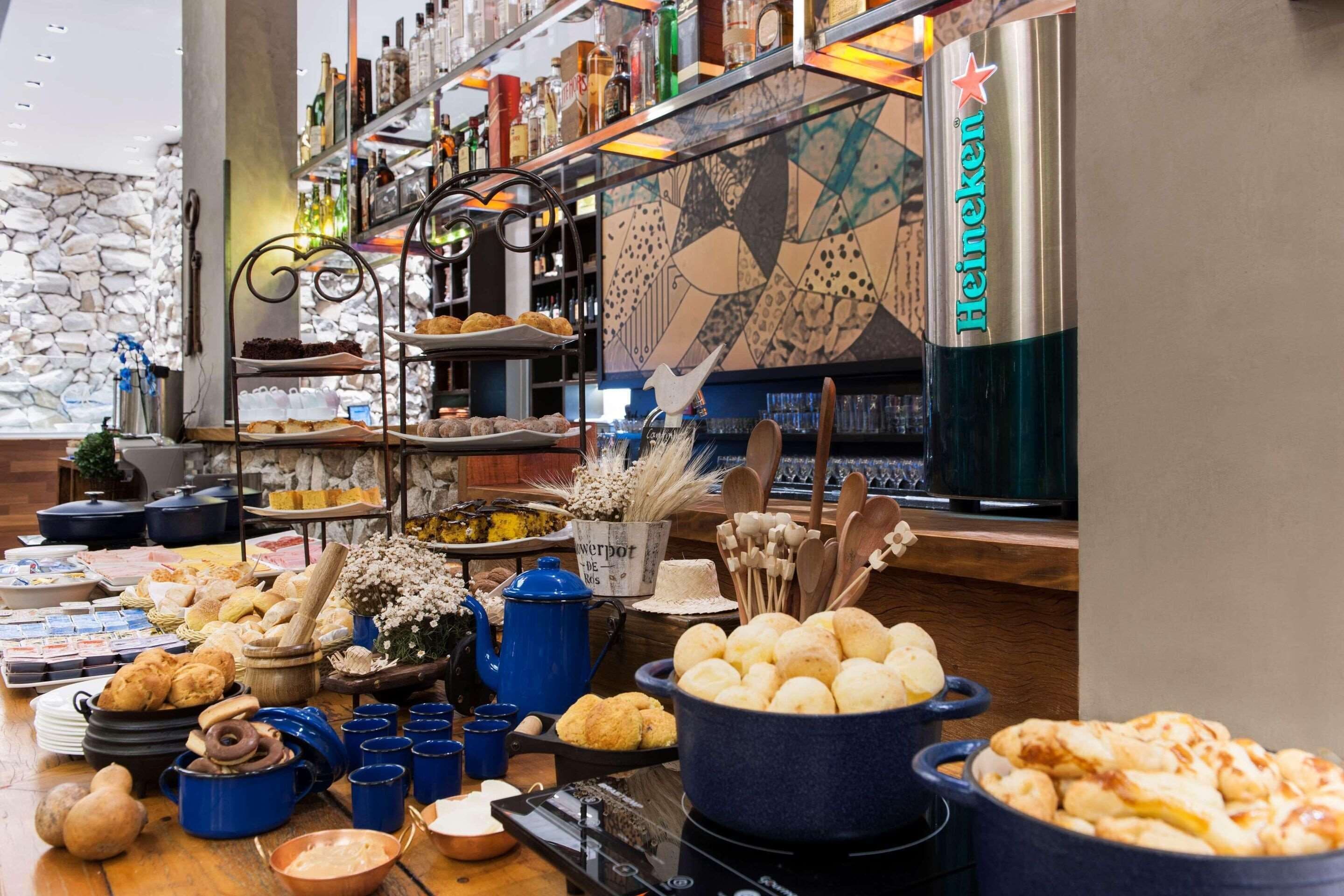 Uma mesa de buffet com diversos alimentos e uma geladeira Heineken.