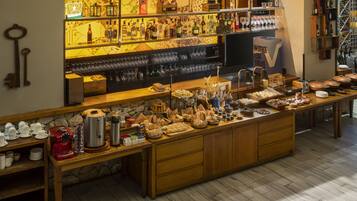 Zona de bar con estantes llenos de botellas, vasos y una máquina de café.