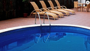 A swimming pool with lounge chairs and a table. - Principe Hotel and Suites (Panama City)