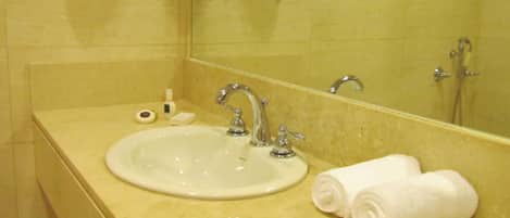 A bathroom with a sink, mirror, and towels.