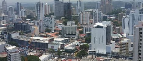 A cityscape with high-rise buildings, a construction site, and a busy street.