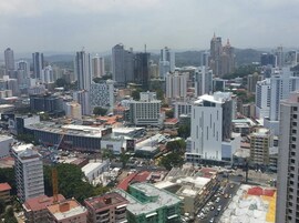 Un paisaje urbano con edificios altos, una obra en construcción y una calle concurrida.