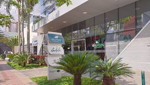 A modern building with a glass facade, a reception area, and a sign for 'esuites'.