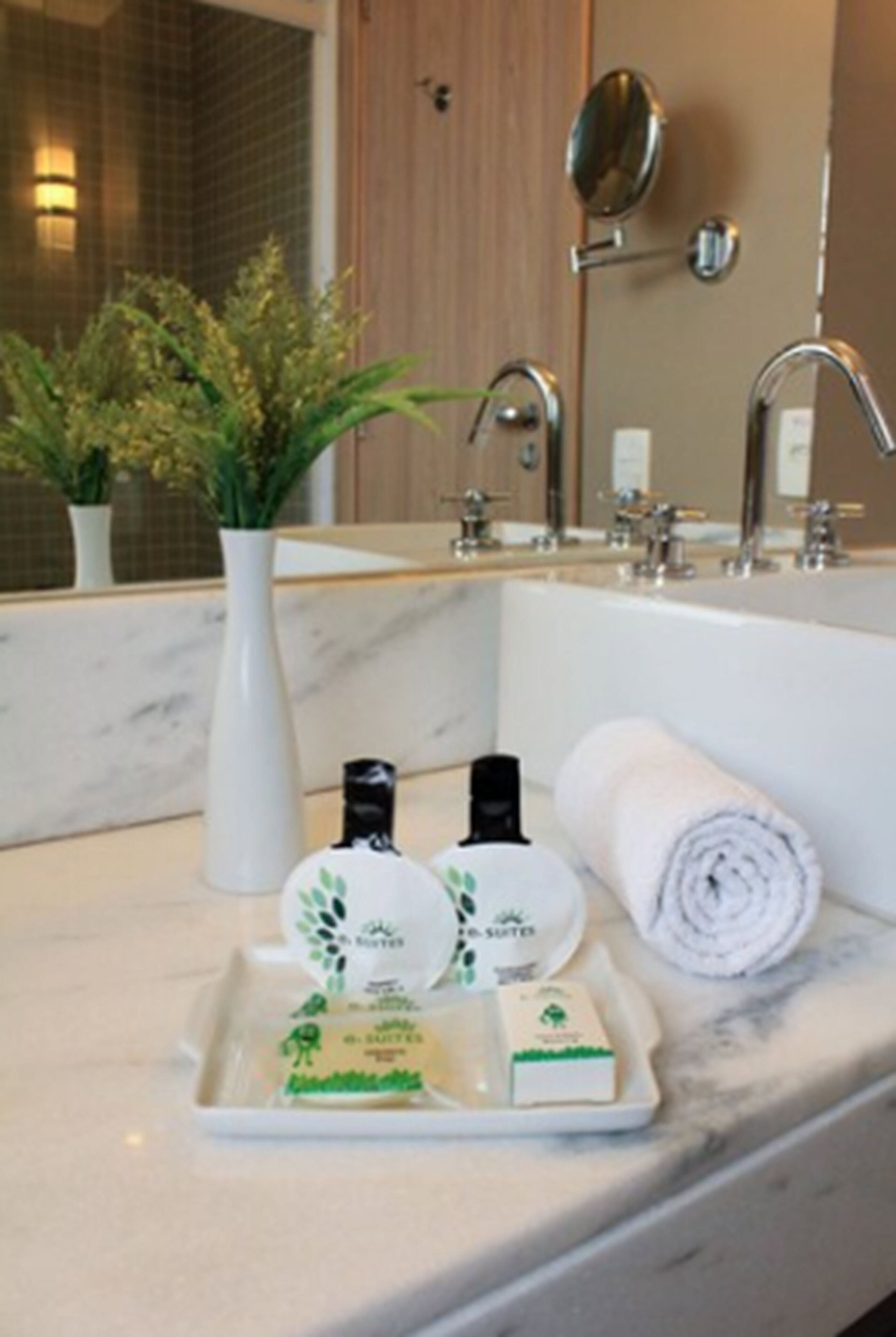 A bathroom with a marble sink, a mirror, a towel, and toiletries.
