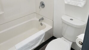 A bathroom with a bathtub, toilet, and a towel rack. - Country Inn Banning (Banning)