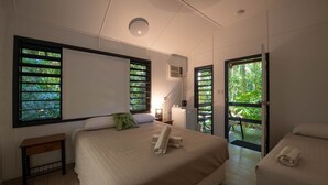 Un dormitorio con una cama grande, una mesita de noche y una ventana con persianas.