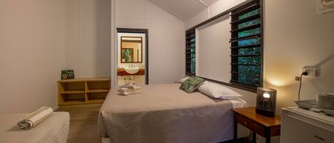 A bedroom with a bed, bedside table, and a nightstand.