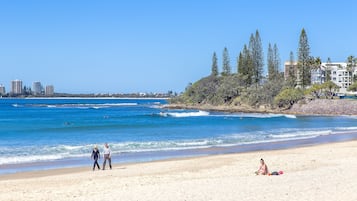 Playa en los alrededores, playa de arena blanca y sombrillas