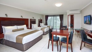 A hotel room with two beds, a dining table with chairs, a TV, and an air conditioning unit. - Best Western Casula Motor Inn (Casula)