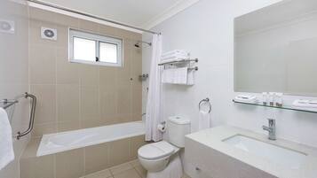 A modern bathroom with a bathtub, toilet, and sink.