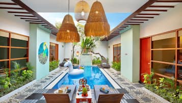 Una piscina al aire libre, sillones reclinables de piscina